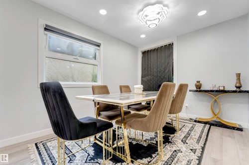 Contemporary dining area featuring light wood-finish flooring, recessed lighting, and a modern ceiling fixture - 7419 33 Avenue Nw, Edmonton, AB - Indoor