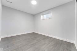 Room featuring light gray walls, wood-finish flooring, white baseboards, and a single window with white trim - 