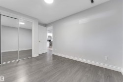 Bedroom featuring wood-finish flooring and light gray painted walls - 