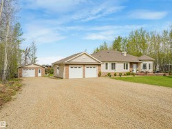 Ranch-style residence featuring a gravel drive, attached double garage, and detached single garage - 