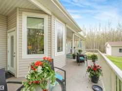 Expansive covered deck featuring light-toned vinyl siding and white railings - 