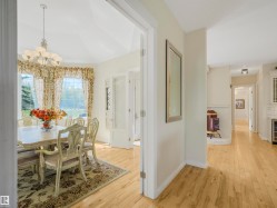 Formal dining room featuring large windows, a chandelier, and wood-finish flooring - 