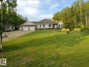 Spacious front lawn with a single-story residence featuring a two-car garage, light-colored siding, and a prominent bay window - 16 Crystal Keys Crescent, Rural Wetaskiwin County, AB  - Outdoor 