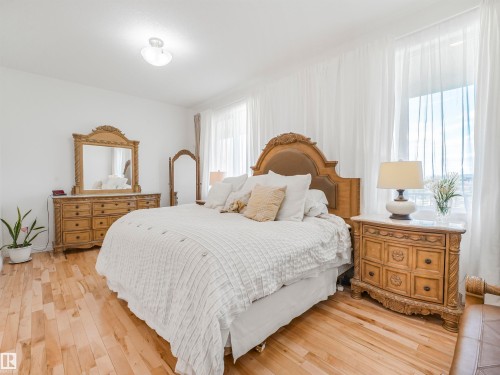 Bright room featuring light wood-finish flooring and multiple windows with sheer drapery - 16 Crystal Keys Crescent, Rural Wetaskiwin County, AB - Indoor Photo Showing Bedroom