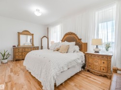 Bright room featuring light wood-finish flooring and multiple windows with sheer drapery - 