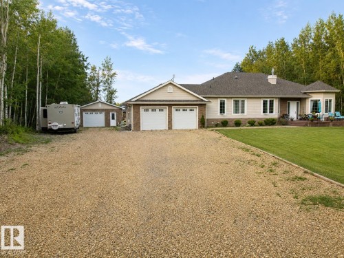 Exterior featuring a large gravel driveway, a two-car attached garage, and a separate single-car detached garage - 16 Crystal Keys Crescent, Rural Wetaskiwin County, AB - Outdoor With Facade