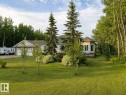 Exterior residence featuring a two-car garage, mature landscaping, a side deck, and surrounding woodland - 16 Crystal Keys Crescent, Rural Wetaskiwin County, AB  - Outdoor 