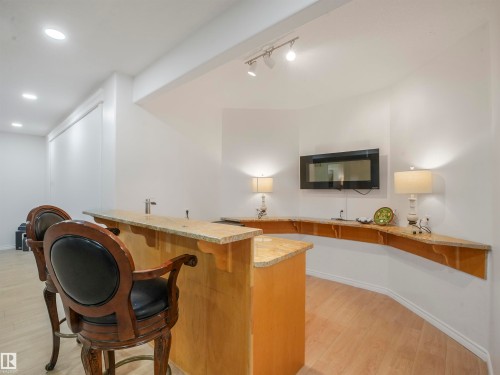 Custom bar area featuring a light wood-finish countertop, integrated sink, and track lighting - 16 Crystal Keys Crescent, Rural Wetaskiwin County, AB - Indoor