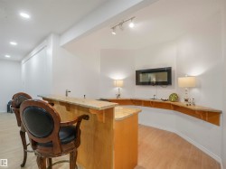 Custom bar area featuring a light wood-finish countertop, integrated sink, and track lighting - 