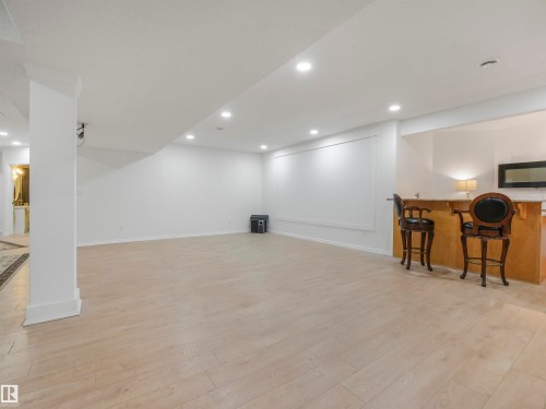 Spacious finished lower level featuring light wood-finish flooring, recessed lighting, and a built-in wet bar with a countertop - 16 Crystal Keys Crescent, Rural Wetaskiwin County, AB - Indoor