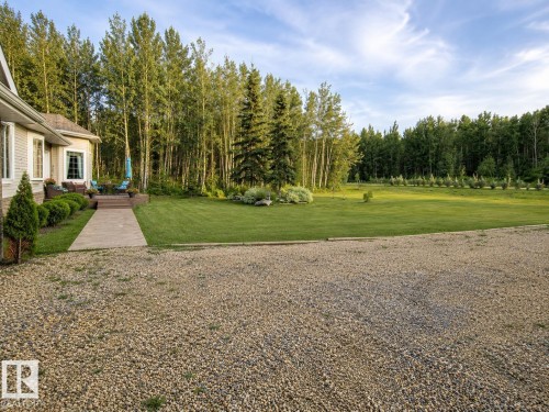 Spacious gravel driveway fronting a manicured lawn - 16 Crystal Keys Crescent, Rural Wetaskiwin County, AB - Outdoor