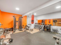 Dedicated fitness space featuring rubber flooring, recessed lighting, and accent walls - 