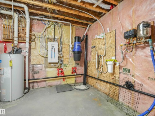Basement utility area featuring a water heater, electrical panel, central vacuum system, water filtration unit, and pressure tank - 16 Crystal Keys Crescent, Rural Wetaskiwin County, AB - Indoor Photo Showing Basement