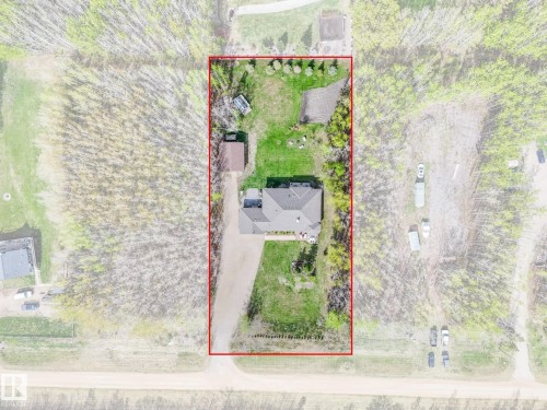 Aerial view showcasing a rectangular property with a single-story residence, extensive green space, a detached outbuilding, and mature trees - 16 Crystal Keys Crescent, Rural Wetaskiwin County, AB -  With View