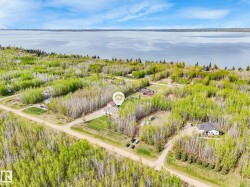 Aerial perspective showcasing the property surrounded by dense deciduous trees - 