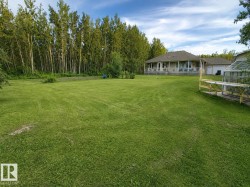 Expansive green lawn with mature trees bordering the property - 