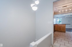 Modern pendant lighting fixtures illuminate this interior space, featuring a light-toned wall finish - 