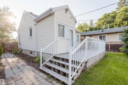 Rear exterior featuring white horizontal siding and a matching white deck with railings - 