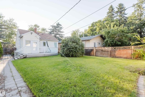 Expansive backyard featuring a lush lawn, paved walkway, and a white deck with railings - 12431 81 Street Nw, Edmonton, AB - Outdoor