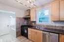 Kitchen featuring light wood cabinetry, a stainless steel dishwasher, and a dual basin sink with a chrome faucet - 12431 81 Street Nw, Edmonton, AB  - Indoor Photo Showing Kitchen With Double Sink 