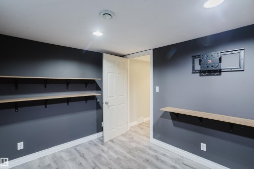 Room featuring light wood-finish flooring, dark gray walls with white trim, and recessed lighting - 12431 81 Street Nw, Edmonton, AB - Indoor Photo Showing Other Room