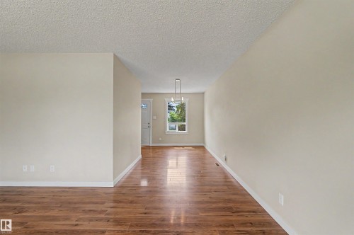 Hardwood-finish flooring extending through an open layout - 8823 130A Avenue Nw, Edmonton, AB - Indoor Photo Showing Other Room