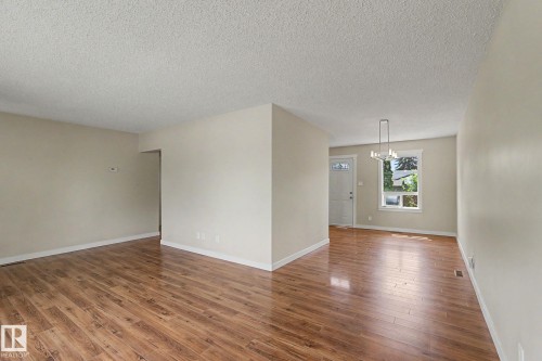 Open-concept living area featuring wood-finish flooring, neutral wall tones, and white trim - 8823 130A Avenue Nw, Edmonton, AB - Indoor Photo Showing Other Room