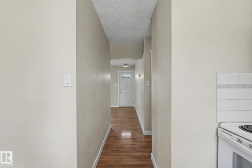Foyer with wood-finish flooring, light-toned walls, and a white entry door with decorative glass - 8823 130A Avenue Nw, Edmonton, AB - Indoor Photo Showing Other Room