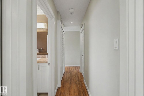 Hallway featuring wood-finish flooring, recessed lighting, and crisp white trim - 8823 130A Avenue Nw, Edmonton, AB - Indoor Photo Showing Other Room