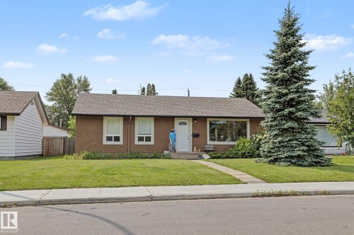 Brown stucco exterior with a white front door and surrounding trim - 8823 130A Avenue Nw, Edmonton, AB - Outdoor