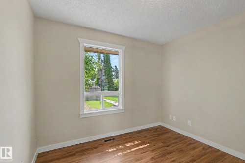 Room featuring a white-trimmed window, wood-finish flooring, and light-toned walls - 8823 130A Avenue Nw, Edmonton, AB - Indoor Photo Showing Other Room