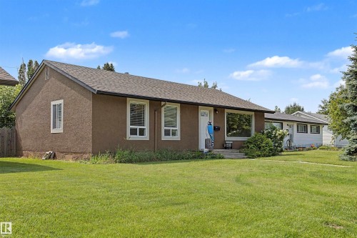 Stucco exterior with a dark shingle roof and white trim windows - 8823 130A Avenue Nw, Edmonton, AB - Outdoor