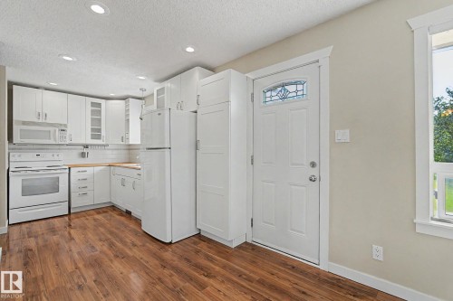 Kitchen featuring wood-finish flooring, white cabinetry, a white subway tile backsplash, and recessed lighting - 8823 130A Avenue Nw, Edmonton, AB - Indoor Photo Showing Kitchen
