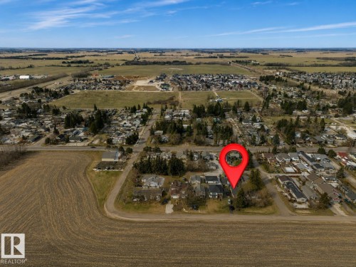 Aerial perspective showcasing a residential area with varied housing styles and mature trees - 4712 49 Street, Calmar, AB - Outdoor With View