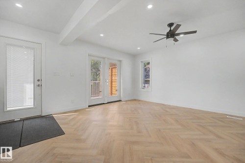 Spacious room featuring herringbone wood-finish flooring, recessed lighting, and a ceiling fan - 10570 66 Avenue Nw, Edmonton, AB - Indoor Photo Showing Other Room