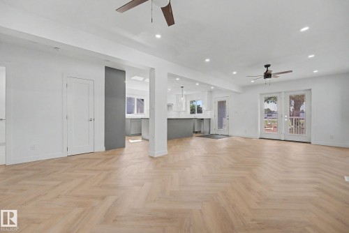 Expansive living space featuring light wood-finish flooring in a herringbone pattern - 10570 66 Avenue Nw, Edmonton, AB - Indoor