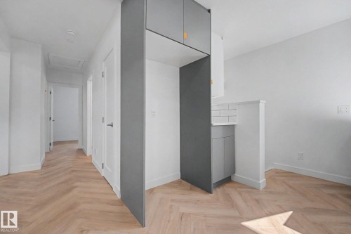 Herringbone wood-finish flooring throughout - 10570 66 Avenue Nw, Edmonton, AB - Indoor Photo Showing Other Room