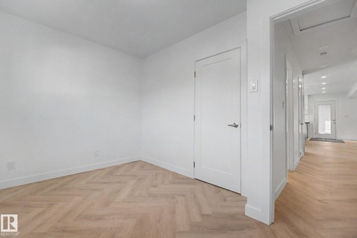 Room featuring wood-finish flooring in a herringbone pattern - 10570 66 Avenue Nw, Edmonton, AB - Indoor Photo Showing Other Room