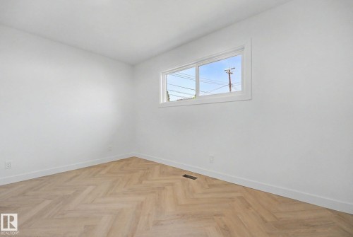Light-filled interior space featuring wood-finish flooring in a herringbone pattern - 10570 66 Avenue Nw, Edmonton, AB - Indoor Photo Showing Other Room