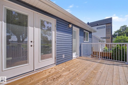 Expansive wood deck with white metal railings - 10570 66 Avenue Nw, Edmonton, AB - Outdoor With Deck Patio Veranda With Exterior