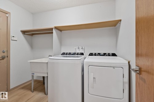 Dedicated laundry area featuring wood-finish flooring and light-toned walls - 2819 33 Street Nw, Edmonton, AB - Indoor Photo Showing Laundry Room