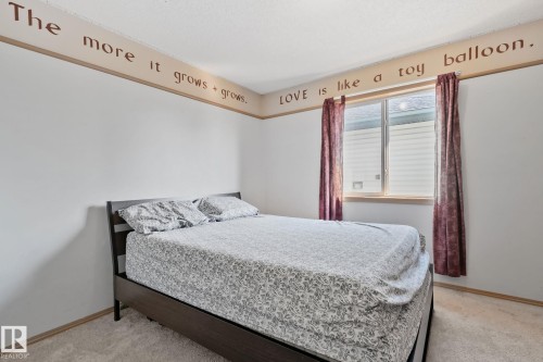 Bright bedroom featuring a large window, neutral wall tones, and light-toned carpeting - 2819 33 Street Nw, Edmonton, AB - Indoor Photo Showing Bedroom