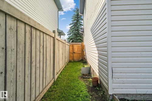 Enclosed side yard featuring a wooden privacy fence, a wooden gate, and a grass pathway - 2819 33 Street Nw, Edmonton, AB - Outdoor With Exterior