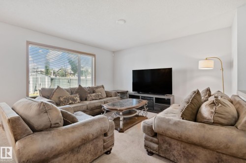 Spacious living area featuring a large window, neutral wall tones, and textured carpeting - 2819 33 Street Nw, Edmonton, AB - Indoor Photo Showing Living Room