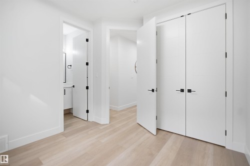 Light wood-finish flooring throughout - 304 33 Avenue Nw, Edmonton, AB - Indoor Photo Showing Other Room