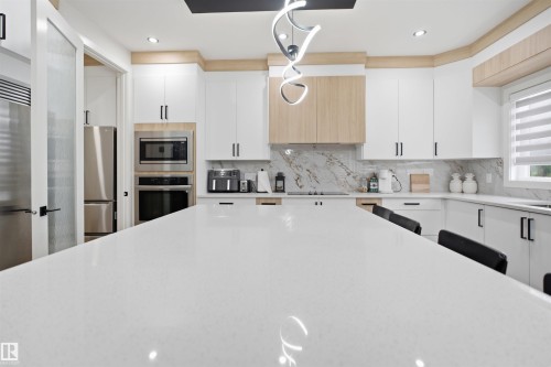 Expansive kitchen island with a light-toned countertop - 304 33 Avenue Nw, Edmonton, AB - Indoor Photo Showing Kitchen