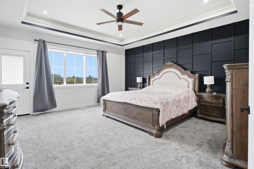 Accent wall with geometric paneling complemented by a tray ceiling with recessed lighting - 304 33 Avenue Nw, Edmonton, AB - Indoor Photo Showing Bedroom