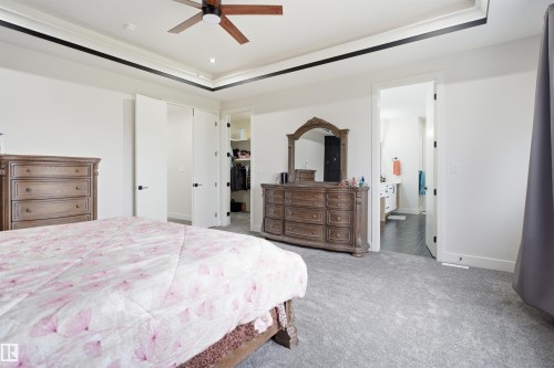 Carpeted bedroom with a tray ceiling and a ceiling fan - 304 33 Avenue Nw, Edmonton, AB - Indoor Photo Showing Bedroom