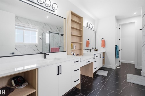 Double vanity featuring integrated sinks, white countertops, matte black fixtures, and extensive white cabinetry - 304 33 Avenue Nw, Edmonton, AB - Indoor
