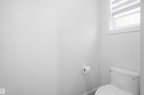 Bathroom featuring a white toilet, white walls, and a window with blinds - 304 33 Avenue Nw, Edmonton, AB - Indoor Photo Showing Bathroom